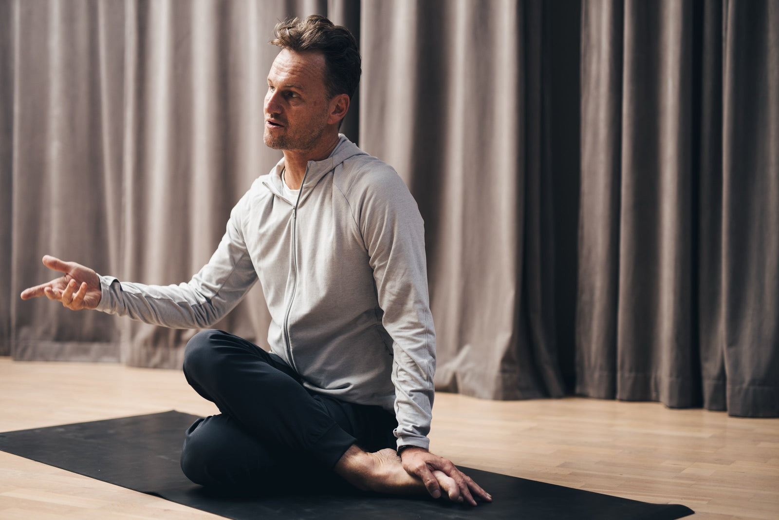Magnus Fridh sitter på mattan och undervisar i Art of Stillness studio